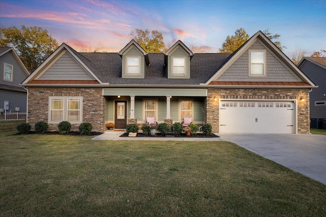 view of front of house with a lawn, a porch, and a garage