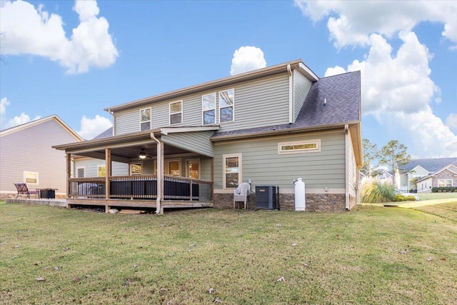 rear view of house with ceiling fan, a yard, central AC unit, and a deck