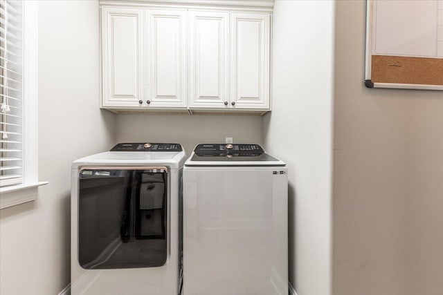 laundry area featuring separate washer and dryer and cabinets