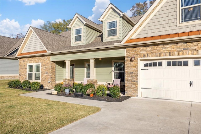 view of front of property featuring a front lawn, a porch, and a garage