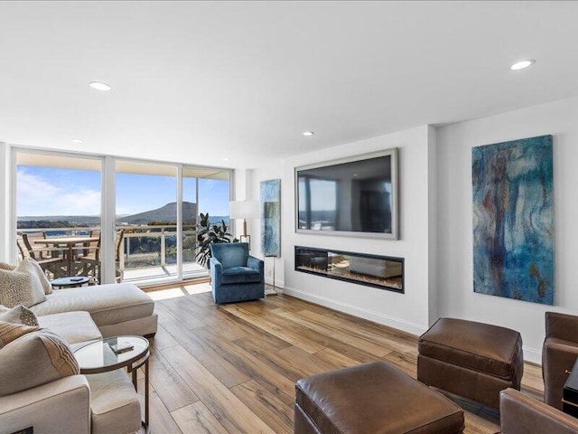 living room with light wood-type flooring and floor to ceiling windows