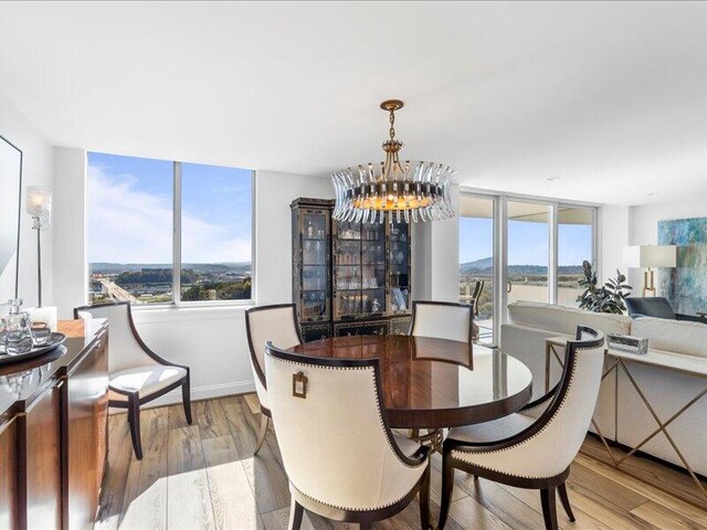 dining room with a notable chandelier and light wood-type flooring