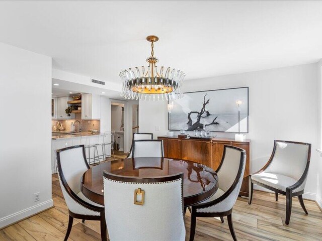 dining space featuring a chandelier and light wood-type flooring