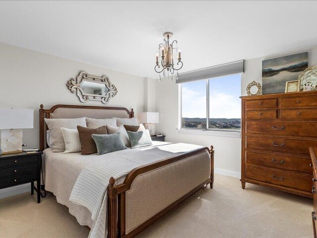 bedroom featuring light carpet and a chandelier