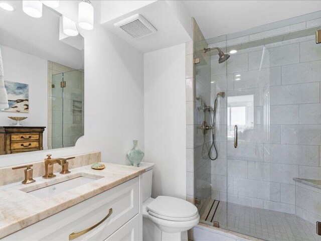 bathroom with vanity, an enclosed shower, and toilet