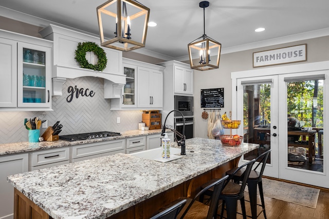 kitchen featuring white cabinets, appliances with stainless steel finishes, and an island with sink