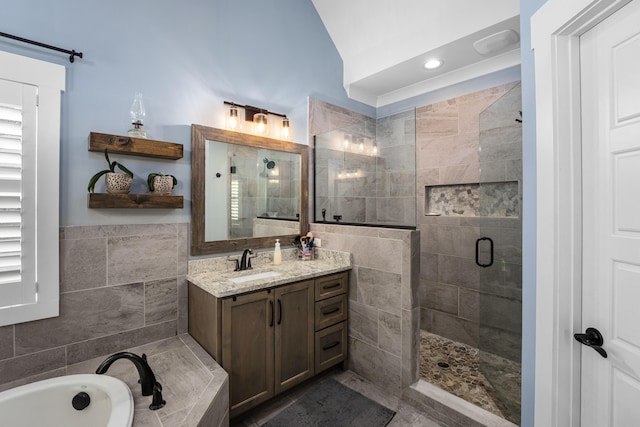 bathroom with vanity, shower with separate bathtub, and tile walls