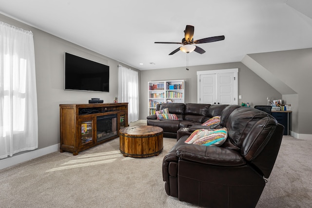 carpeted living room with ceiling fan and lofted ceiling