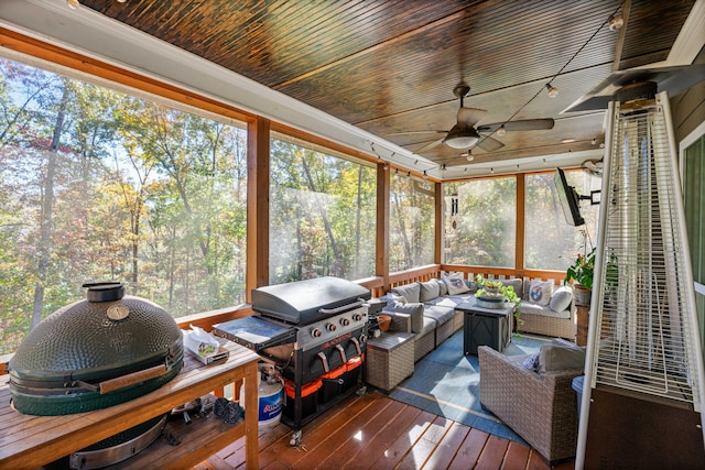 sunroom / solarium featuring ceiling fan and wood ceiling