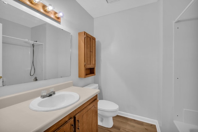 bathroom featuring walk in shower, toilet, vanity, and hardwood / wood-style flooring