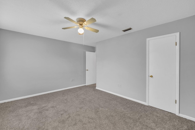 spare room with carpet, ceiling fan, and a textured ceiling