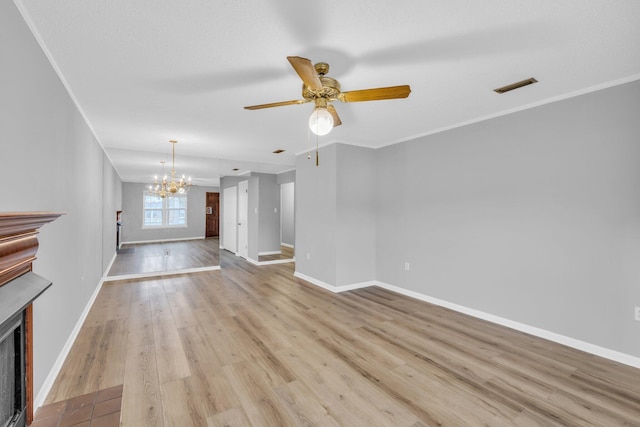 unfurnished living room featuring ceiling fan with notable chandelier, light hardwood / wood-style flooring, and ornamental molding