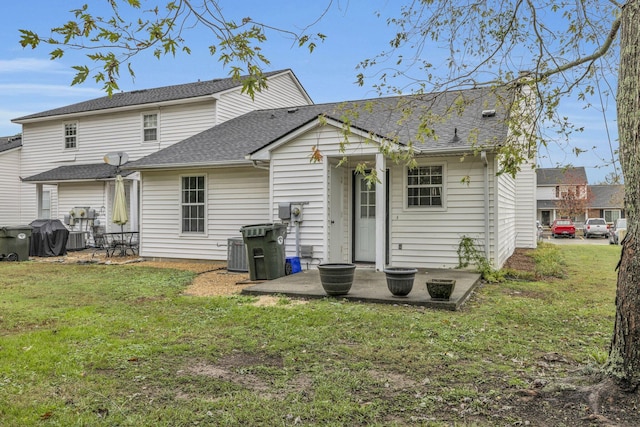 rear view of house featuring central air condition unit, a patio area, and a lawn