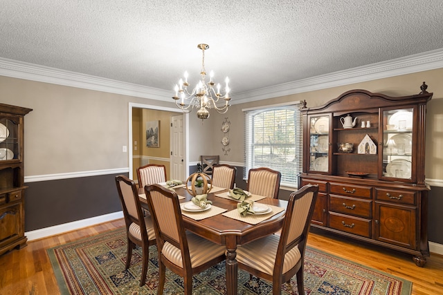 145 County Road 573, Englewood, TN 37329 - dining area with a chandelier, a textured ceiling, ornamental molding, and light wood-style floors