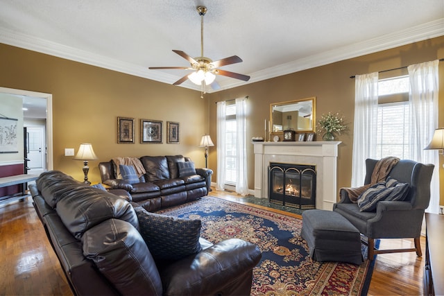 145 County Road 573, Englewood, TN 37329 - living area featuring a ceiling fan, wood-type flooring, a tiled fireplace, and crown molding