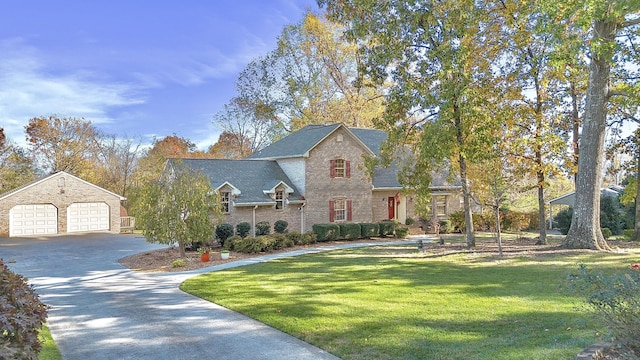 145 County Road 573, Englewood, TN 37329 - view of front facade featuring an outdoor structure, a front lawn, concrete driveway, brick siding, and a garage