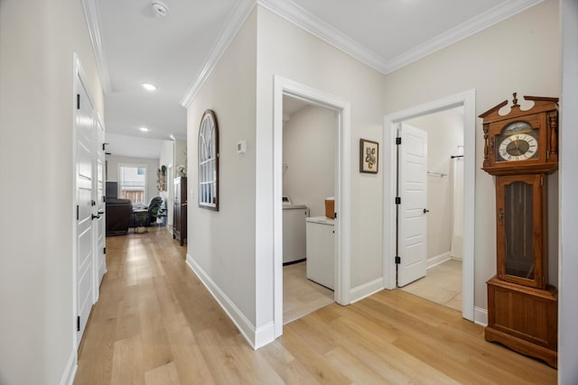 hallway featuring ornamental molding, washer / clothes dryer, and light hardwood / wood-style flooring