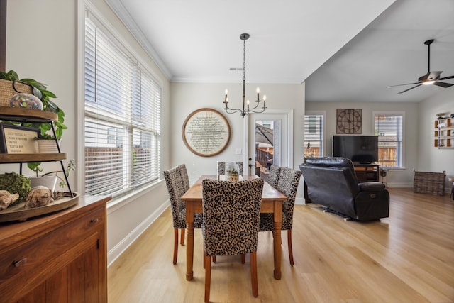 dining room featuring ceiling fan with notable chandelier, light wood-type flooring, and a healthy amount of sunlight