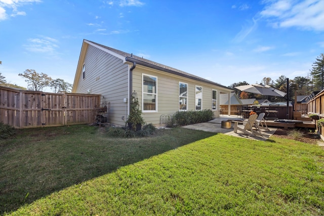 back of property with a yard and a patio area