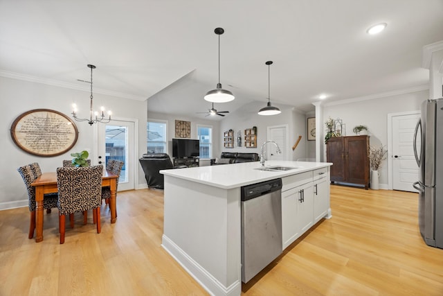 kitchen featuring stainless steel appliances, sink, decorative light fixtures, a center island with sink, and white cabinetry