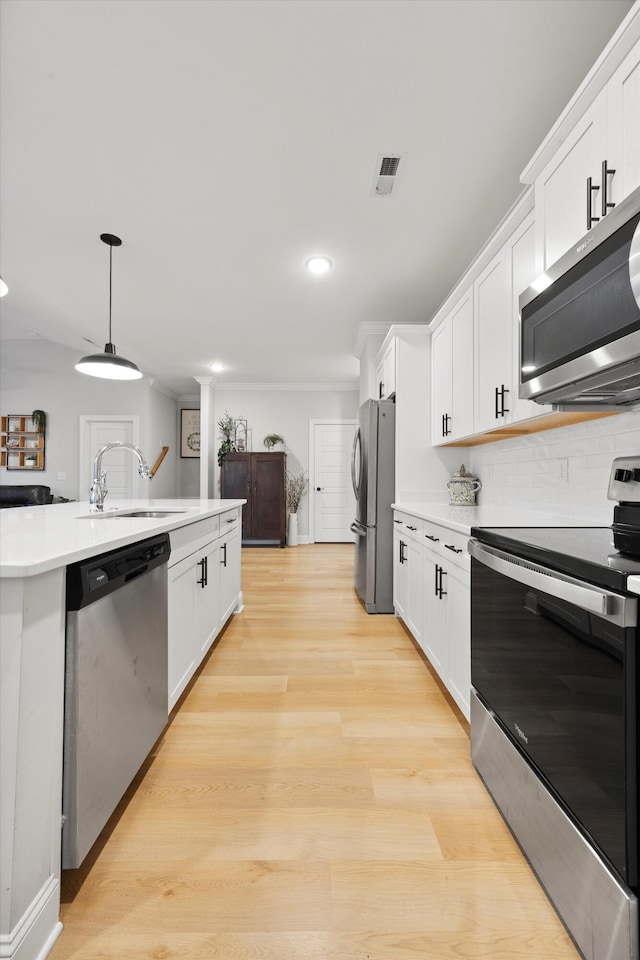 kitchen with white cabinets, backsplash, stainless steel appliances, and hanging light fixtures