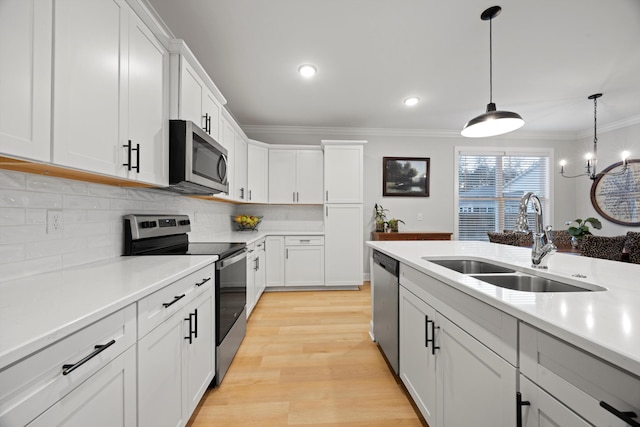 kitchen featuring appliances with stainless steel finishes, white cabinetry, and sink