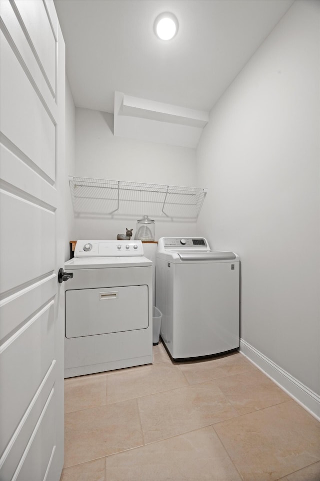 laundry area with light tile patterned flooring and washer and dryer