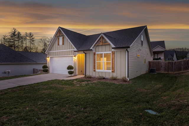 view of front facade with central AC, a yard, and a garage