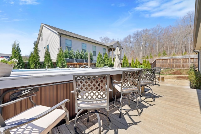 wooden terrace featuring outdoor dry bar and fence