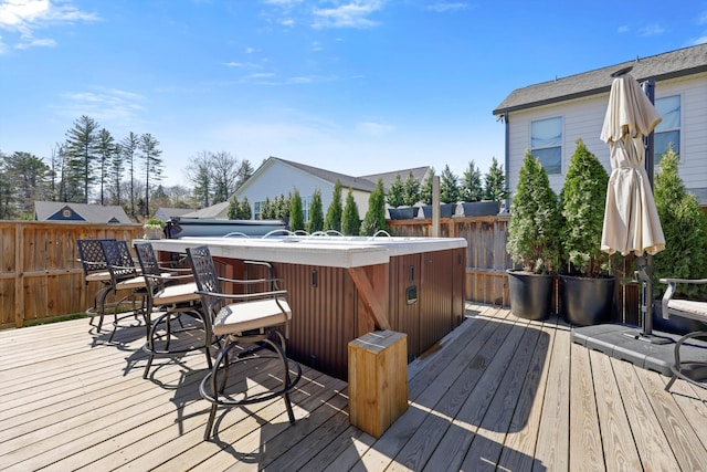 wooden deck with a hot tub and fence