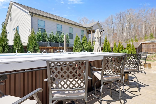wooden terrace featuring outdoor dry bar and fence