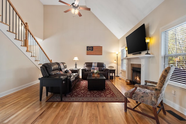 living room with ceiling fan, high vaulted ceiling, and wood-type flooring