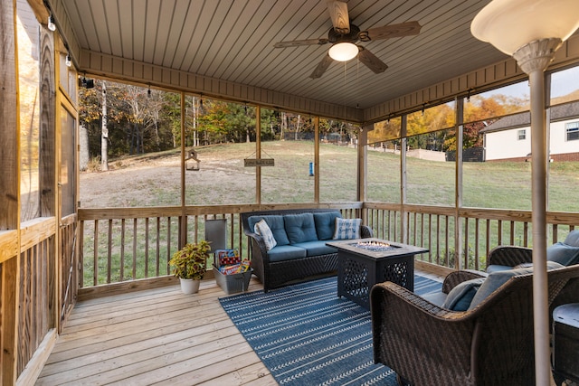 sunroom featuring ceiling fan and wooden ceiling