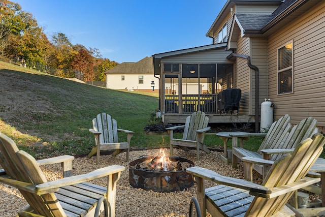 view of patio / terrace with a sunroom and an outdoor fire pit