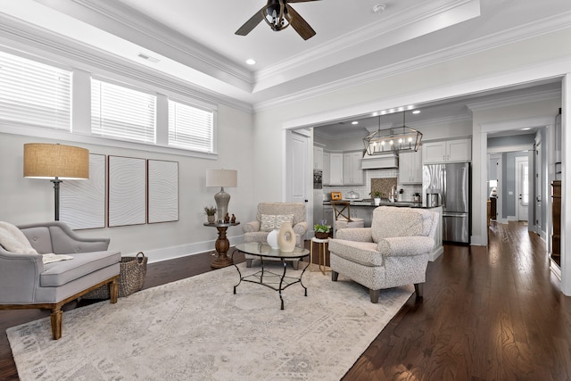 living room featuring dark hardwood / wood-style flooring, a raised ceiling, ceiling fan, and ornamental molding