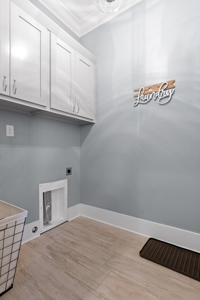 clothes washing area with hookup for an electric dryer, cabinets, light wood-type flooring, and crown molding