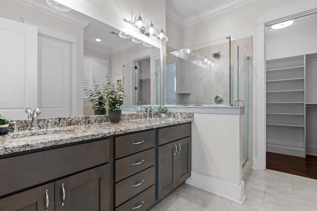 bathroom featuring tile patterned flooring, vanity, an enclosed shower, and ornamental molding