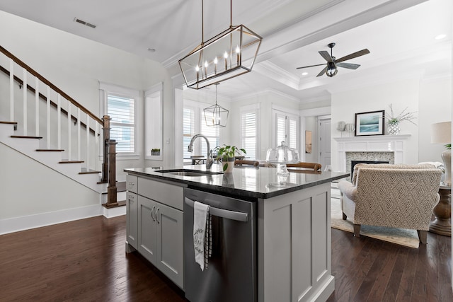 kitchen with pendant lighting, stainless steel dishwasher, ceiling fan, an island with sink, and dark hardwood / wood-style flooring