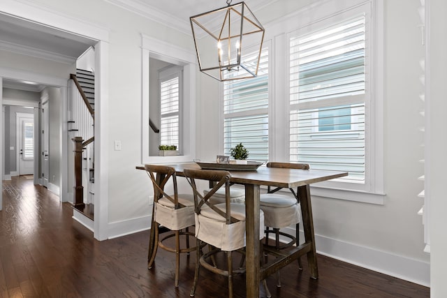 dining room featuring dark hardwood / wood-style flooring, an inviting chandelier, crown molding, and a healthy amount of sunlight