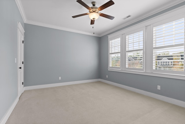 carpeted spare room with a wealth of natural light, crown molding, and ceiling fan