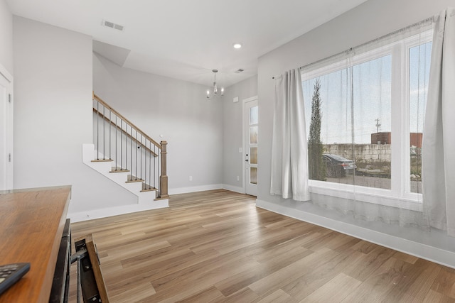 entrance foyer with light wood-type flooring and an inviting chandelier