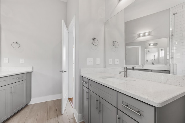 bathroom featuring a shower with door and vanity