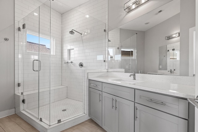 bathroom with hardwood / wood-style floors, vanity, and walk in shower