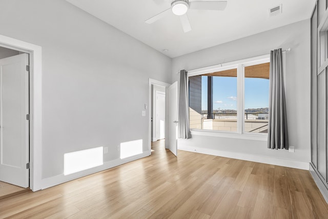 empty room with ceiling fan and light wood-type flooring