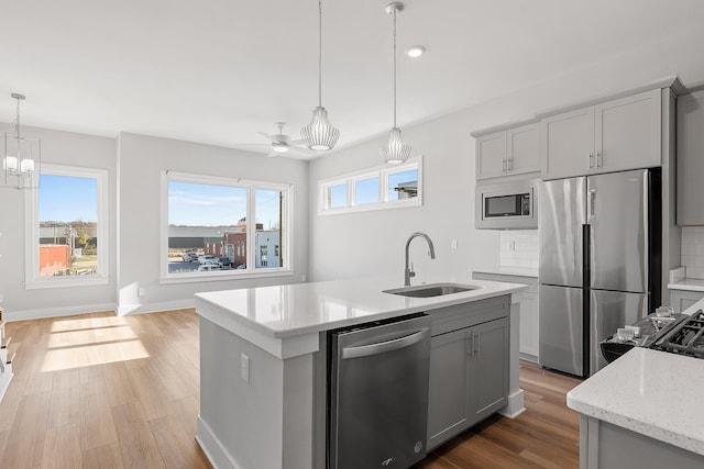 kitchen with appliances with stainless steel finishes, gray cabinets, and sink