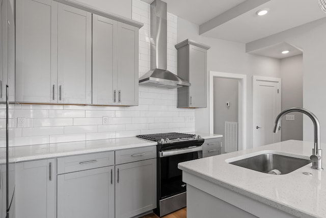 kitchen with light stone countertops, sink, wall chimney exhaust hood, backsplash, and stainless steel electric stove