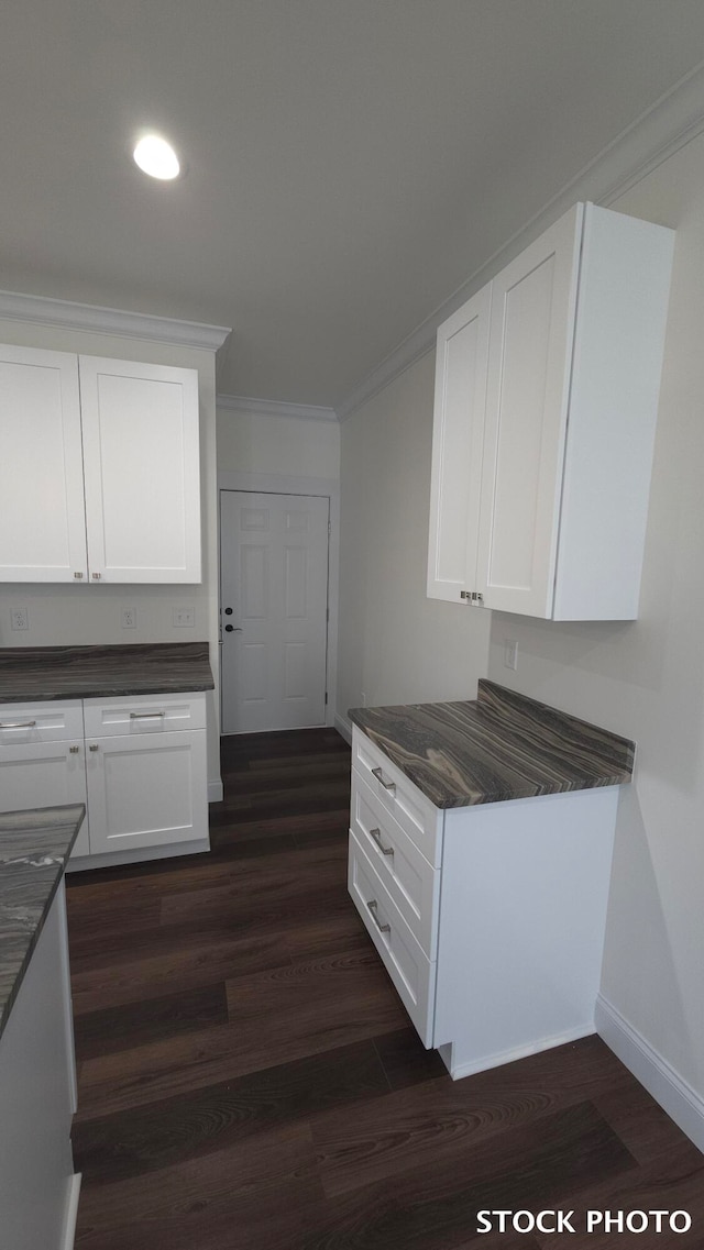 kitchen featuring dark hardwood / wood-style flooring, white cabinetry, and ornamental molding