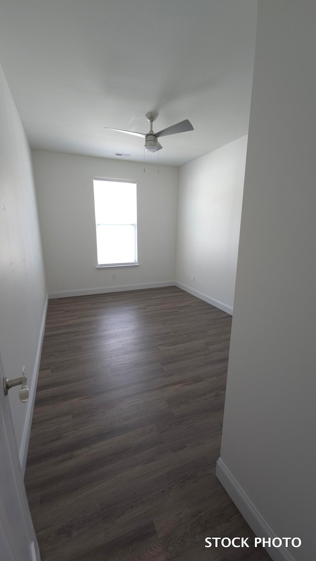 empty room with dark hardwood / wood-style floors and ceiling fan