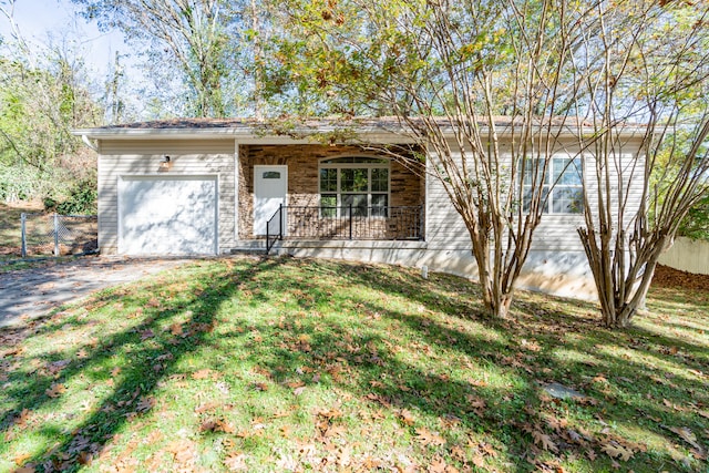 single story home featuring a front lawn, covered porch, and a garage