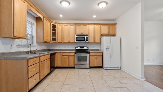 kitchen with stainless steel appliances, sink, and light tile patterned floors